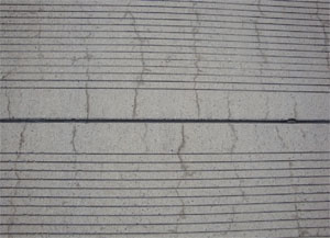Close-up photo of a PCC joint with fine cracks perpendicular to the joint. The cracks appear to be very tight with no visible signs of spalling.