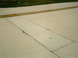 Overview photo of a transverse joint with a rectangular PCC patch along the joint in one of the slabs. The patch is in very good condition with no visible signs of distress.