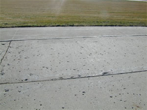 Overview photo of a PCC pavement with widespread popouts. The popouts are visible in the photo as 'holes' in the surface where individual pieces of aggregate have come loose from the pavement's surface.