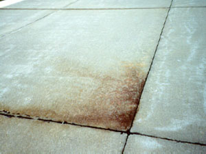 Overview photo of a slab corner where the pavement surface at the corner is discolored. The discoloring (or staining) of the surface is actually subgrade material that has been ejected from the subgrade due to pumping.