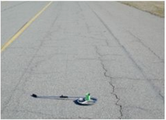 This picture shows an asphalt taxiway pavement with a good amount of block cracking.  The PCI of the pavement in the image is 60.