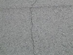 Close-up photo of a single low-severity crack.  The crack is tight and has no visible spalling.